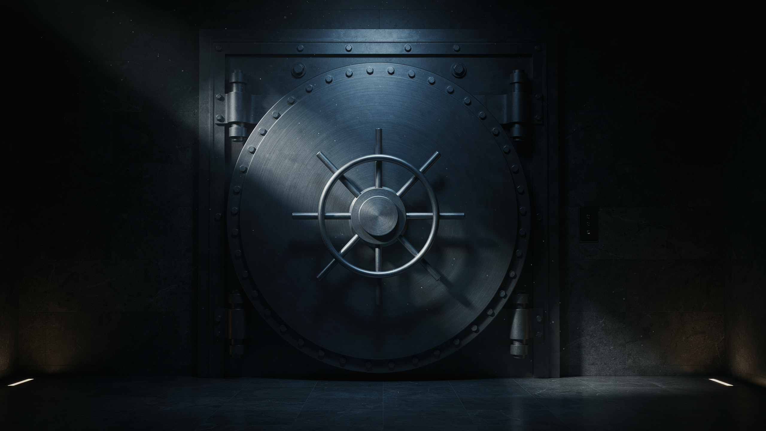 A steel bank vault door with a wheel handle in a dark room, lit by subtle light from above and below.